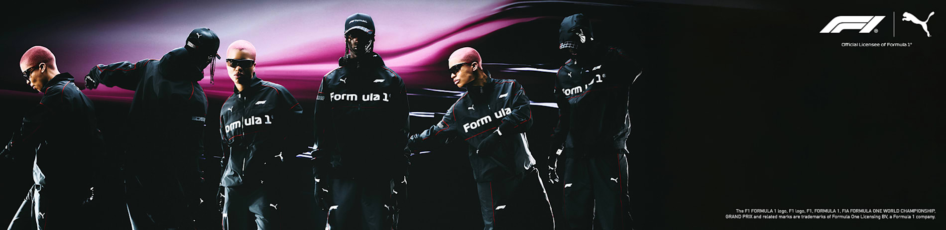 Modellen in Formule 1-kleding staan tegen een vage, dynamische roze achtergrond.