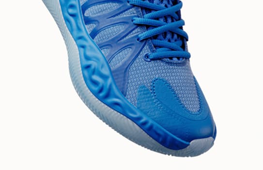 A close-up shows a blue athletic shoe with laces on a white background.