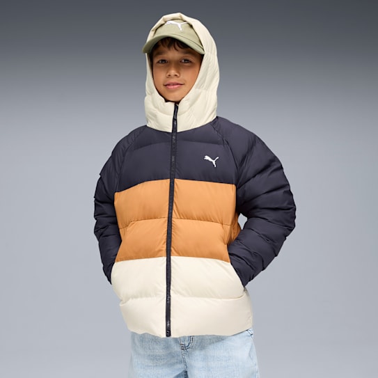 Against a grey backdrop, a child wears a colour-blocked hooded jacket and a cap.