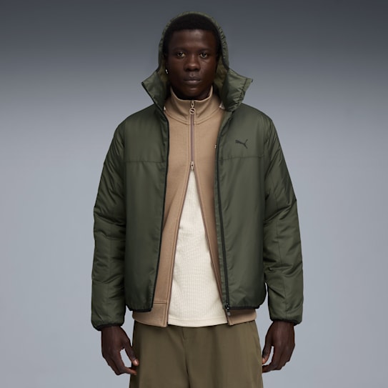Vor grauem Hintergrund trägt ein Model eine grüne Kapuzenjacke mit Puma-Logo.