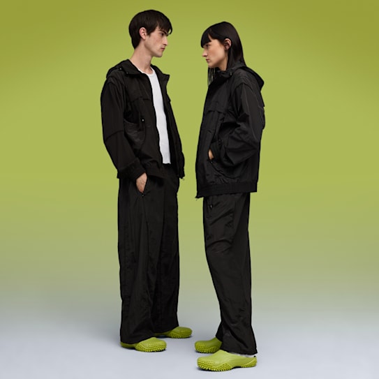 Sur fond vert, des modèles en tenues noires et chaussures citron vert se font face.