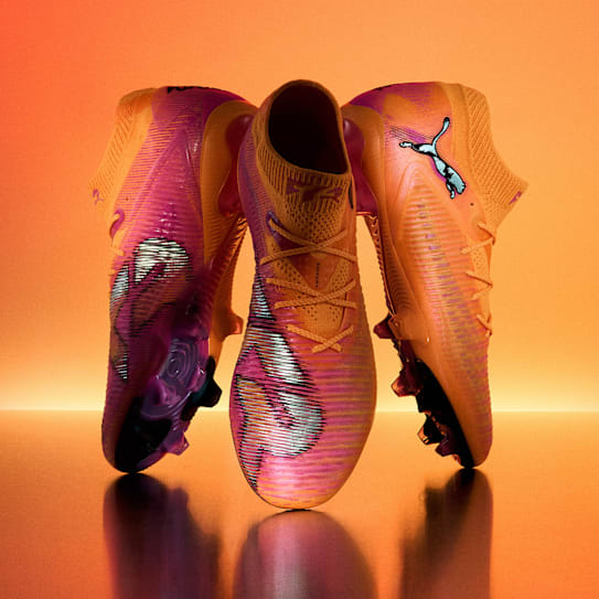 A close-up of a football boot with red and black detailing against a blue backdrop.