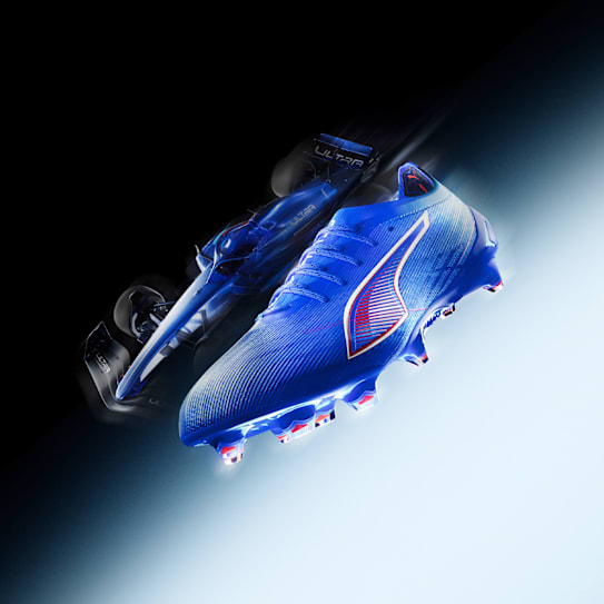 Une chaussure de foot bleue est présentée avec une voiture de course floutée.