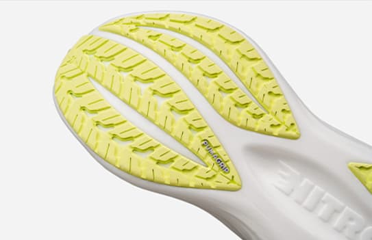 Close-up of a yellow running shoe sole with a textured grip pattern and 'PUMAGRIP' branding.