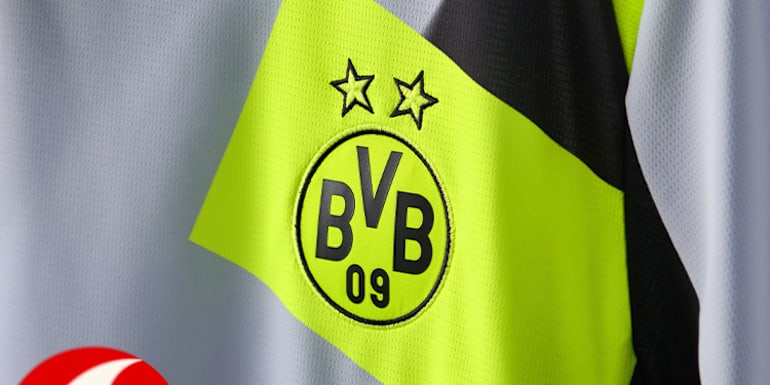 Close-up of a BVB away shirt with the club's logo and two stars on a vibrant yellow panel.